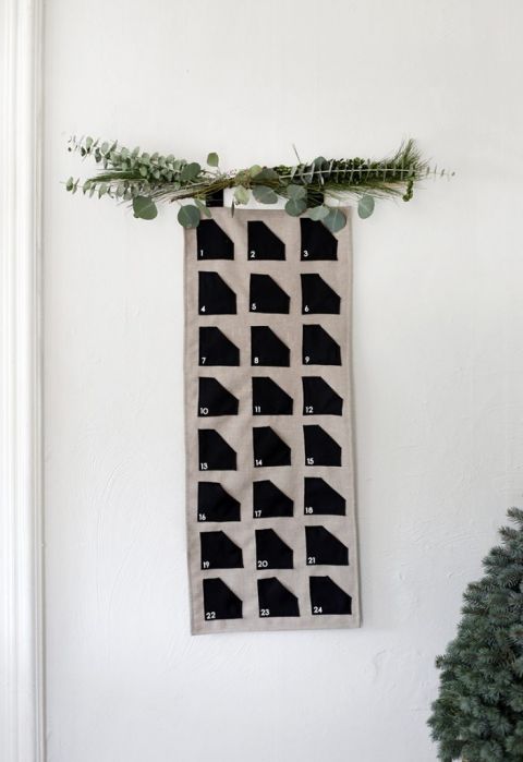 fabric advent calendar with greenery hanging above it