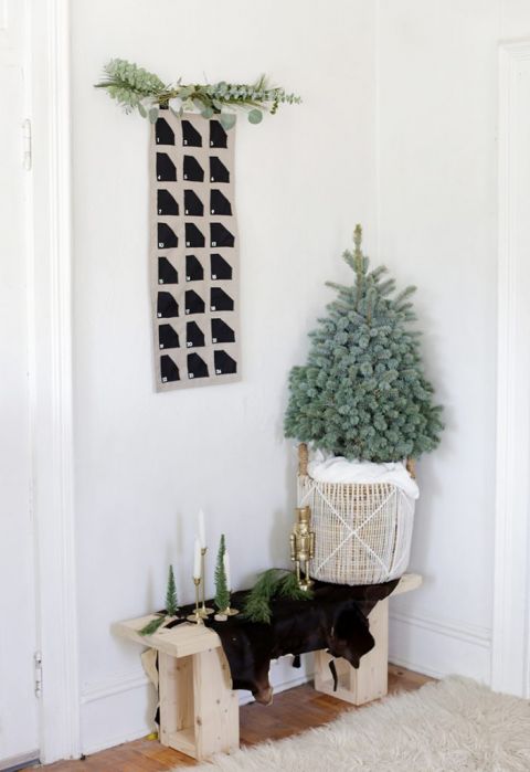 fabric advent calendar on wall above mini Christmas tree in basket