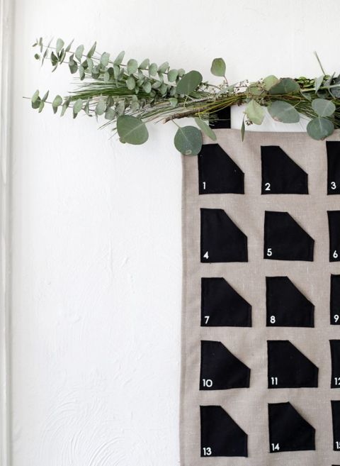 close up of fabric advent calendar with greenery hanging above it