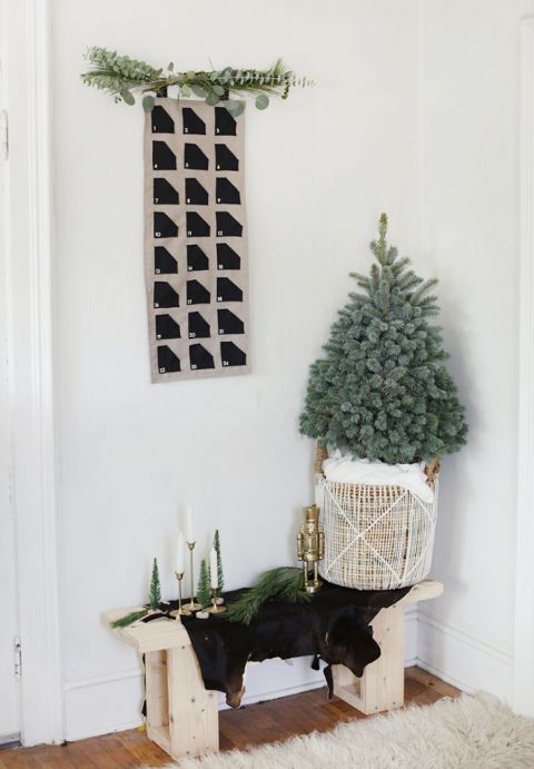 fabric advent calendar on wall above mini Christmas tree in basket