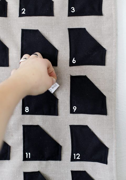 close up of hand pulling activity card out of advent calendar