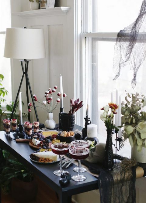 candles and charcuterie boards on black table with halloween decor