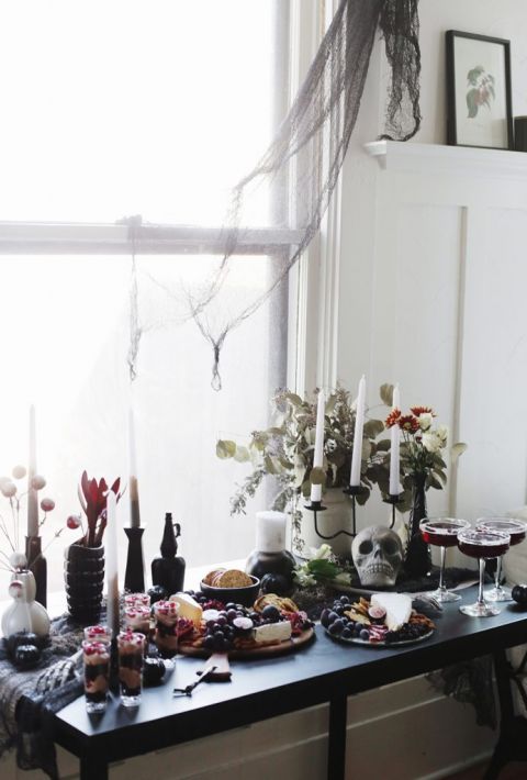 candles and charcuterie boards on black table with halloween decor