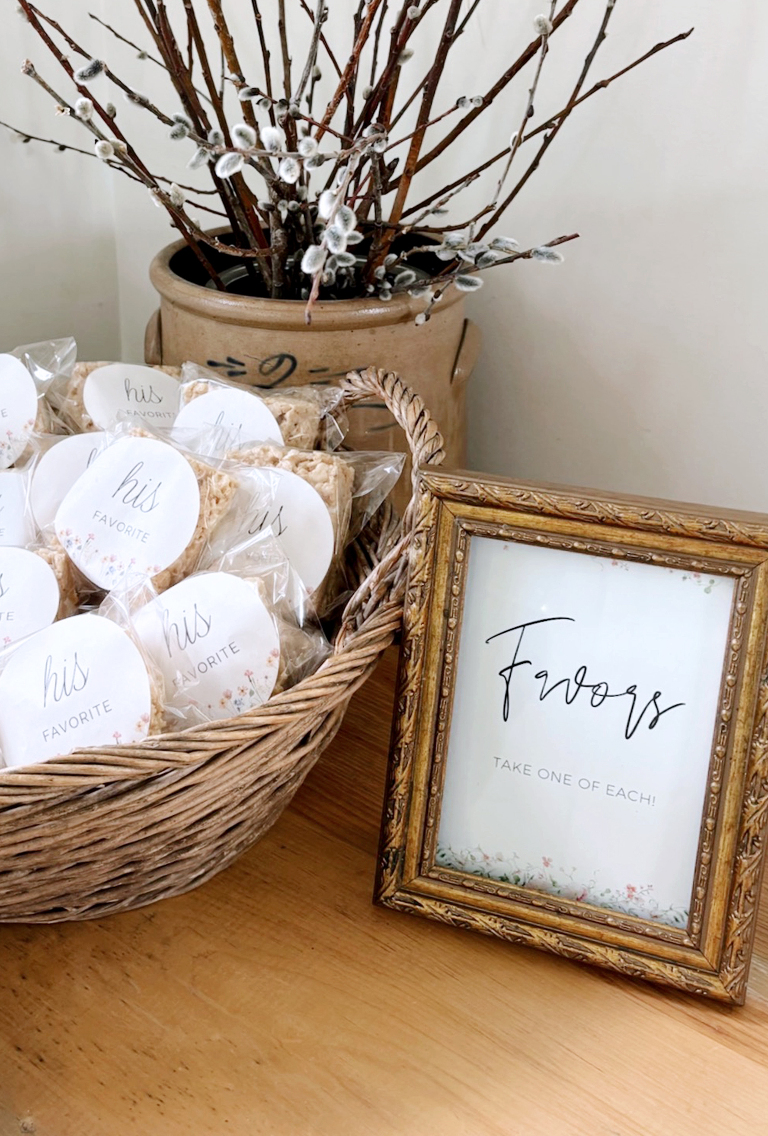 bridal shower favor sign in gold vintage frame next to basket of favors