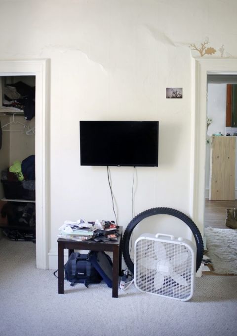 wall mounted tv with table and mess underneath