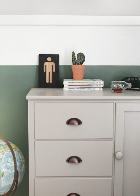 gray dresser with plant and books on it