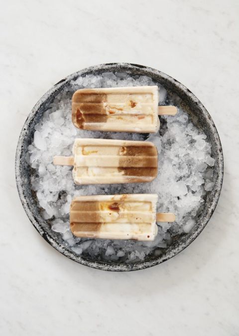 three caramel cold brew coffee popsicles on ice in pie plate