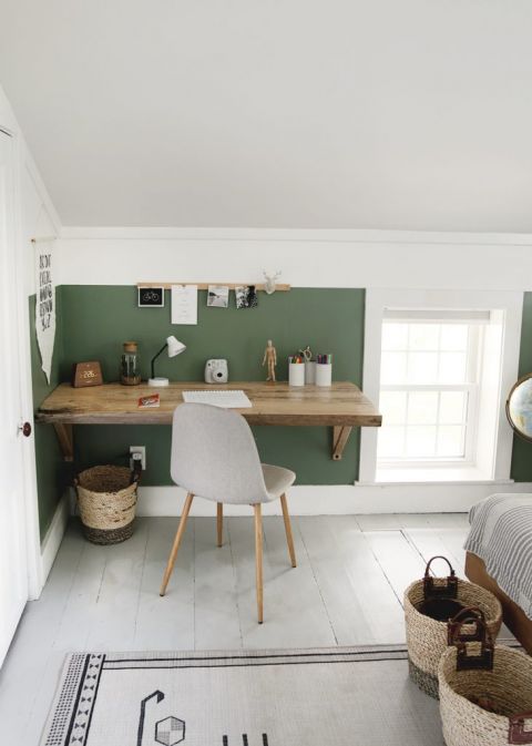 wood slab desk against green and white wall