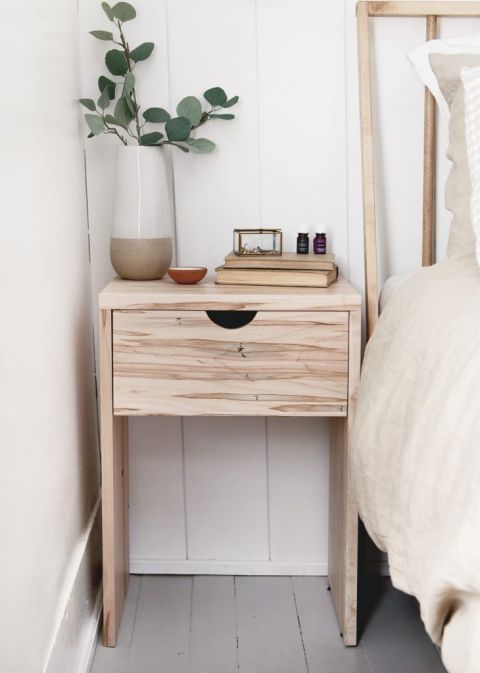 nightstand with one drawer with vase and books on it