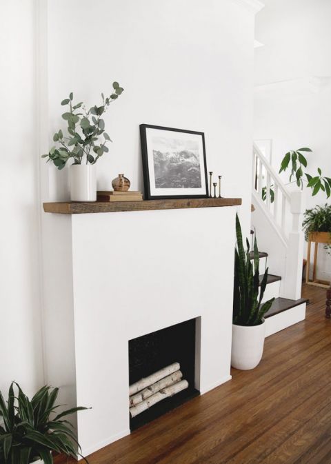 white fireplace surround with wood mantle