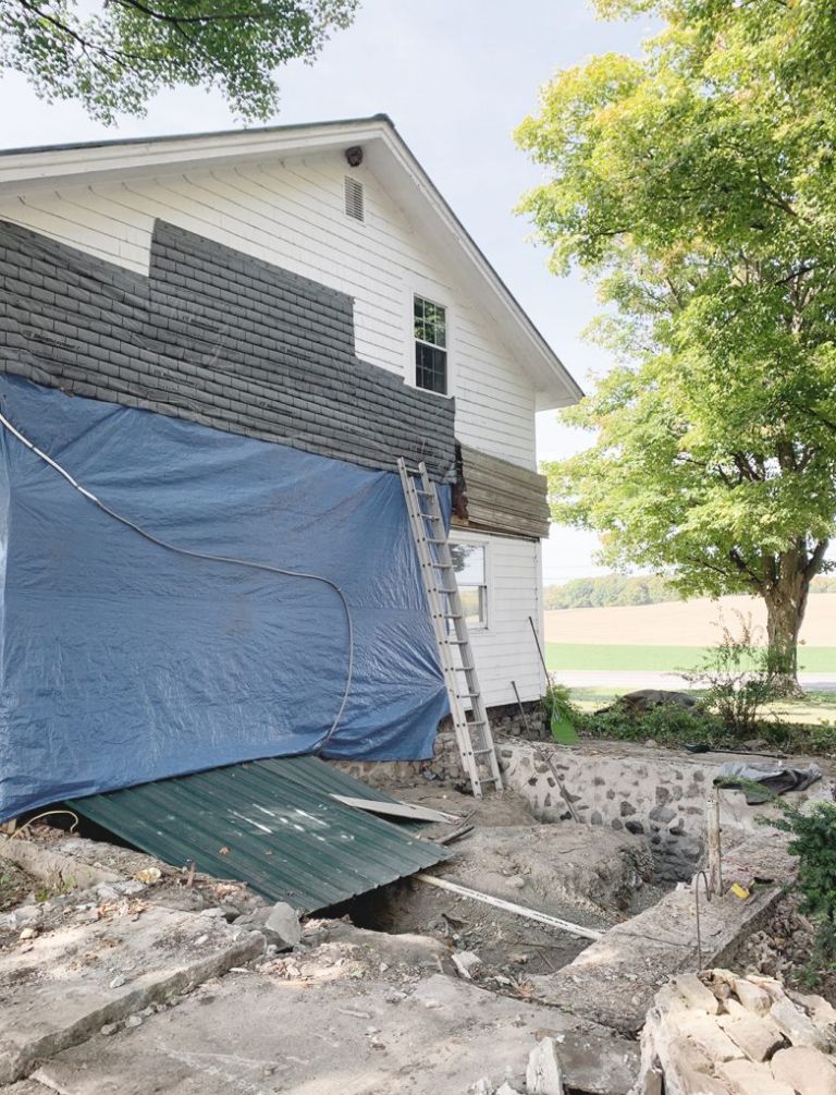 side of house covered by blue tarp