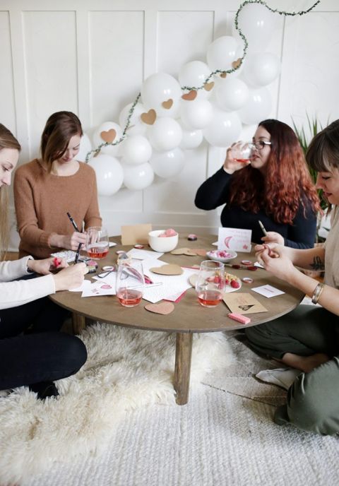 girls around coffee table making Valentine's Day cards