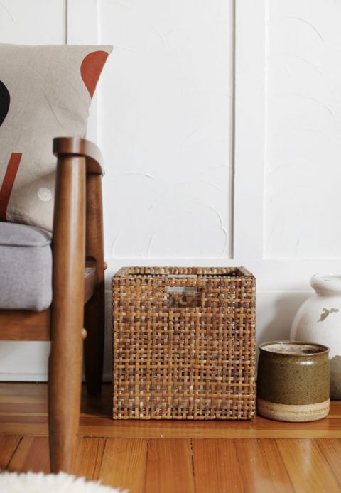 stained square basket next to couch leg