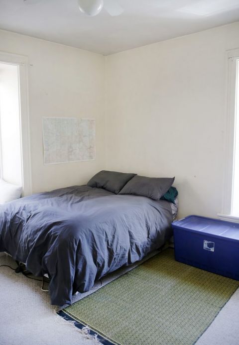 grey bed next to blue plastic tote