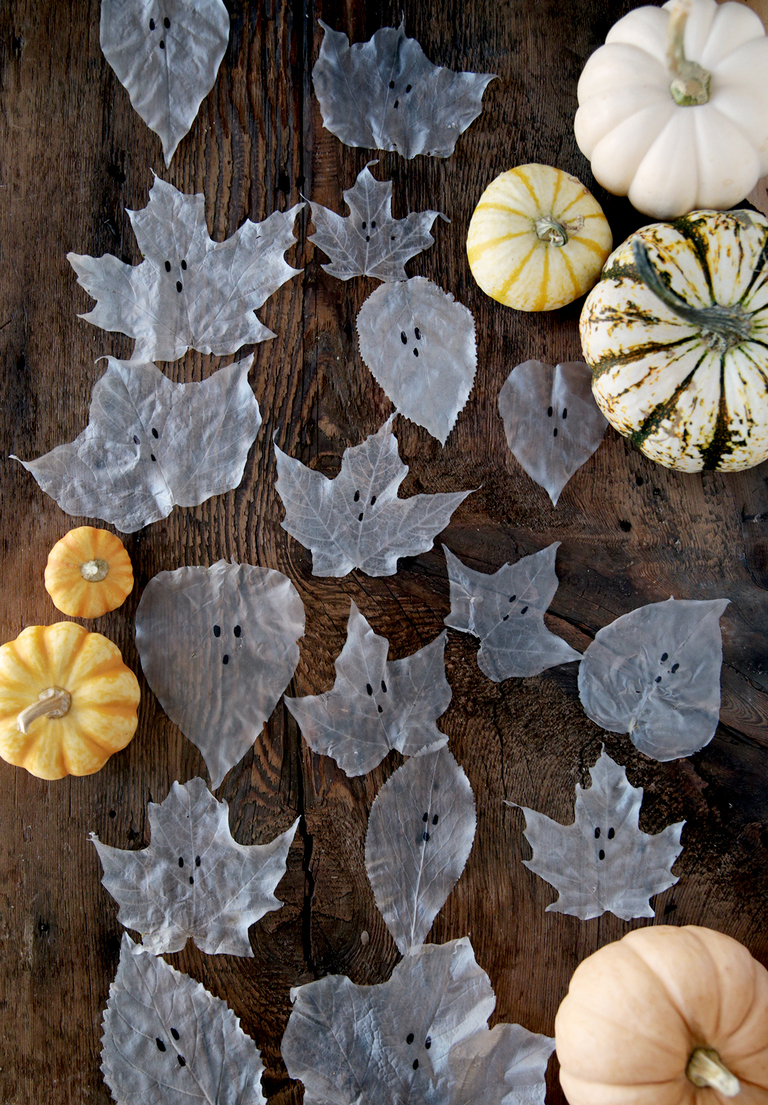 wood board with glue leaf ghosts and mini pumpkins on it