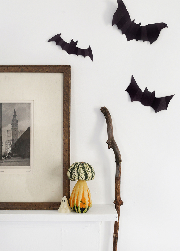mushroom pumpkin next to vintage frame and bats on wall