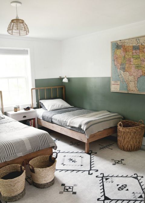 room with green paint on lower half and wood dowel twin bed