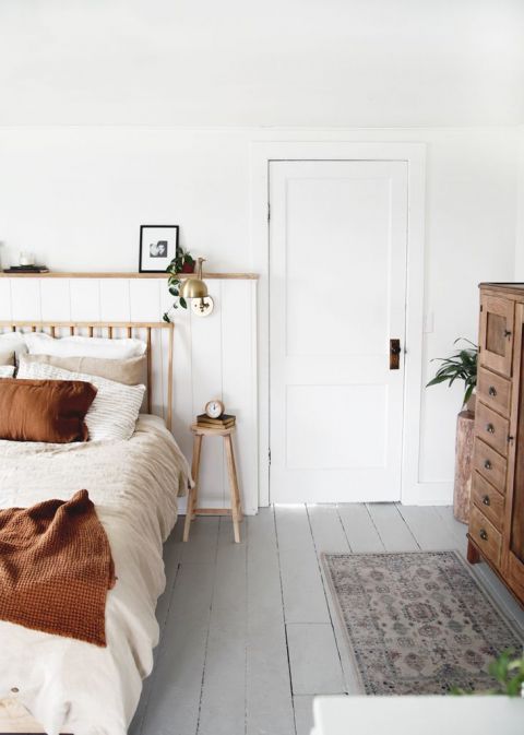 bedroom with white walls wood bed and stool nightstand