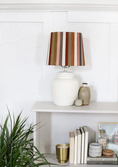lamp with striped string lampshade on the top of bookcase