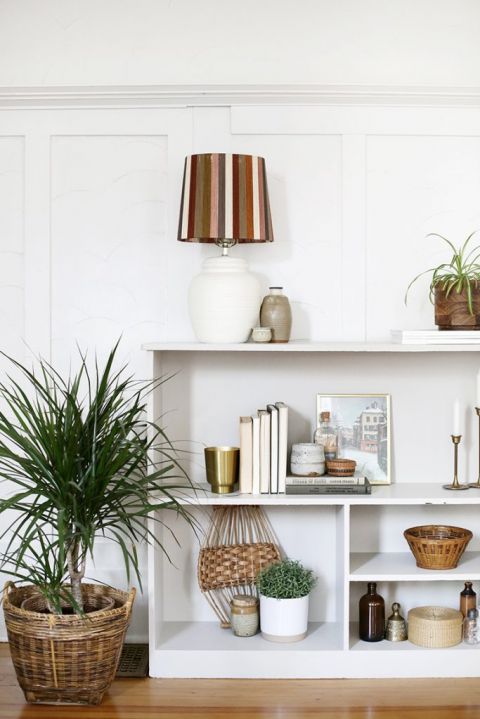 shelf styled with books and plants and candles