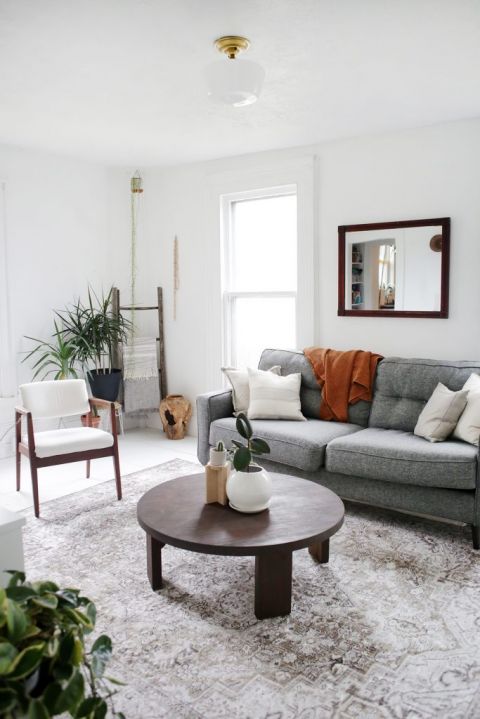 white living room with grey cough and circular coffee table
