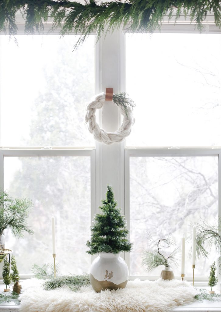 small Christmas tree and wreath in window