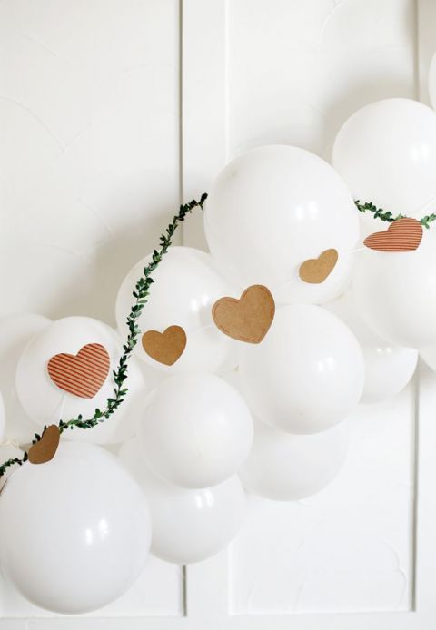 white balloon garland with greenery and Kraft paper hearts