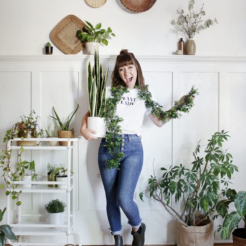 woman wearing plant lady costume surrounded by plants