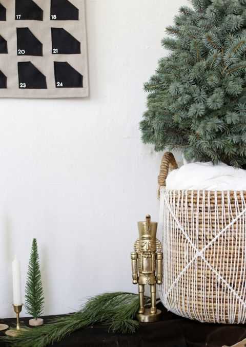 close up of gold nutcracker next to a Christmas tree in a basket