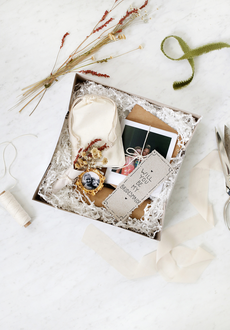 open box filled with photos and sentimental objects surrounded by extra materials