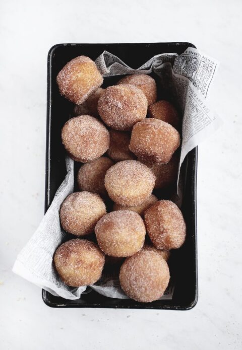 black pan filled with cinnamon sugar muffin donuts