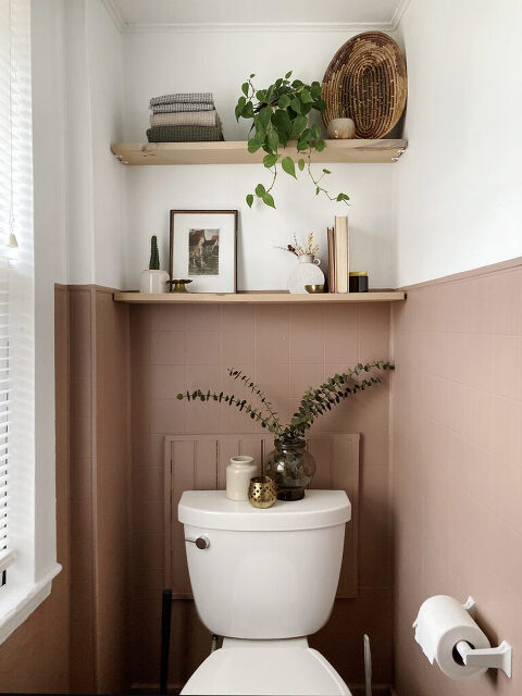 wall shelves behind toilet styled with neutral decor
