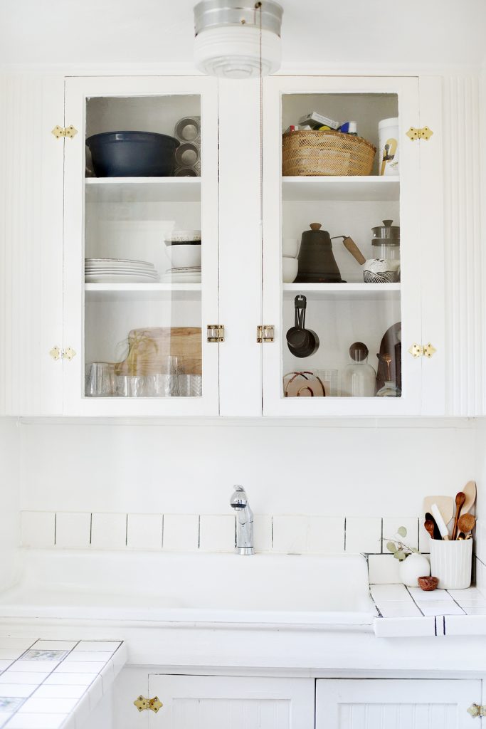 white kitchen cupboards and sink with natural wood accents
