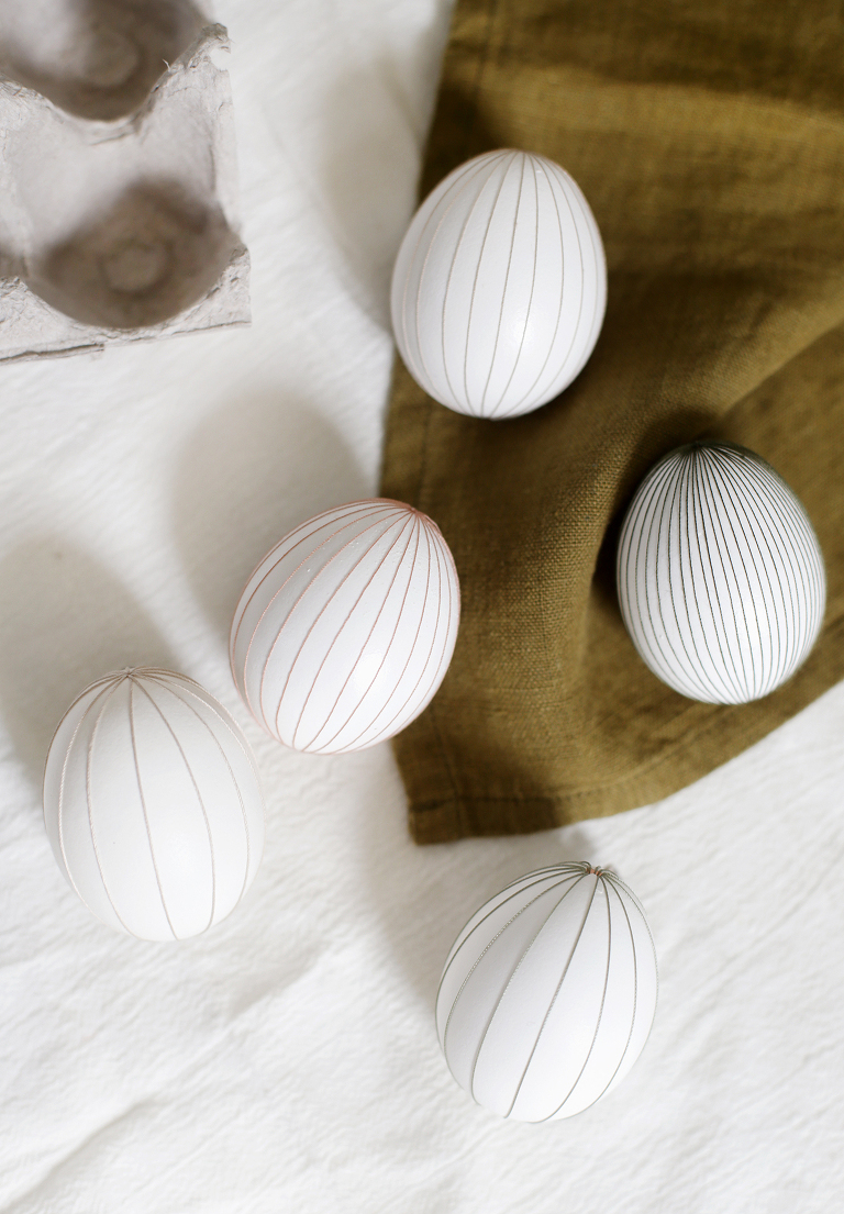 five diy string eggs on various linens