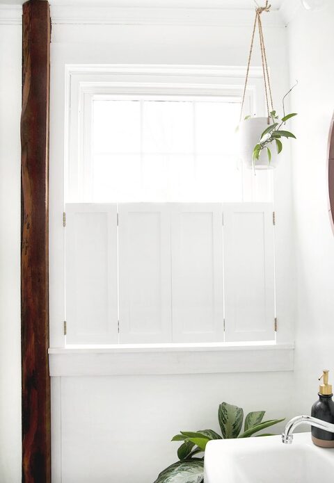 window with closed interior window shutters with wood beam next to window