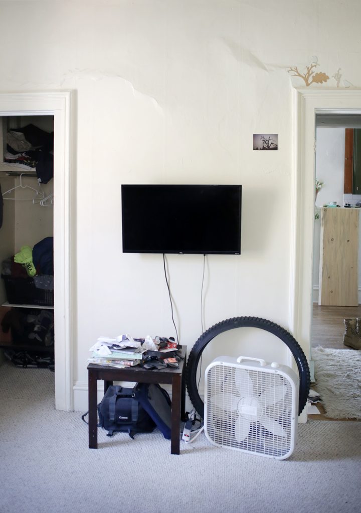 wall mounted tv with table and mess underneath