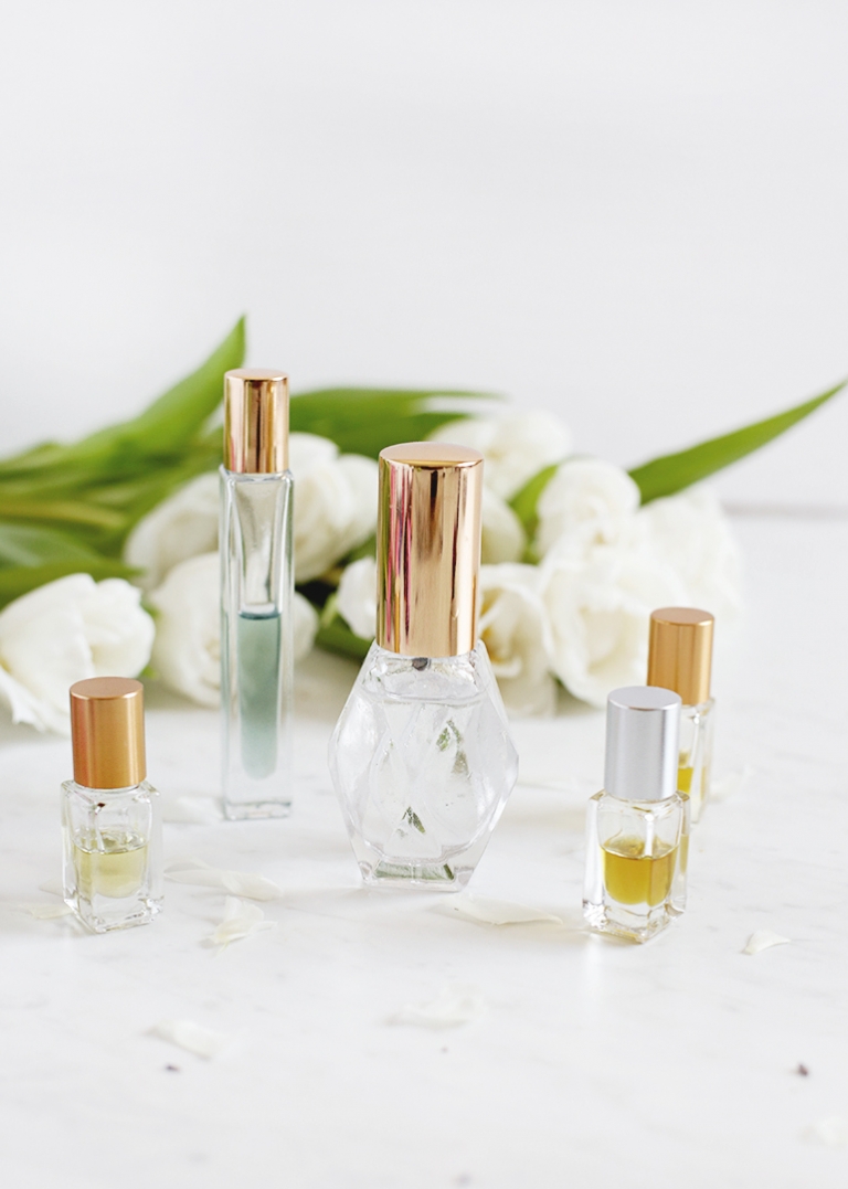 five glass perfume bottles with flowers