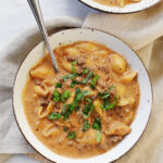 bowl of pasta with basil on top on linen napkin