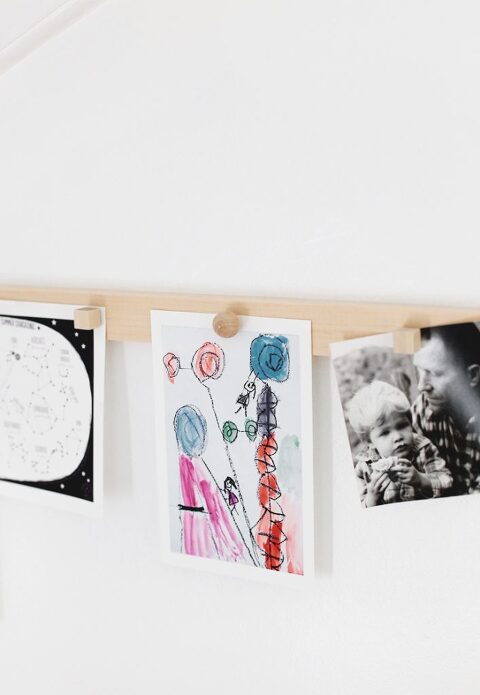 diy wood magnetic display rail with photos hanging from it with wood magnets