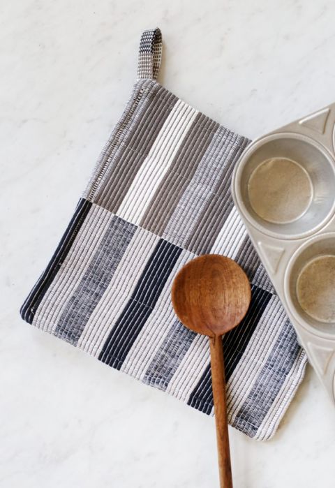 close up of striped potholder with muffin tin and wooden spoon