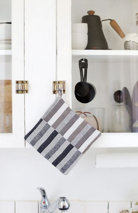 striped potholder hanging on kitchen cabinet