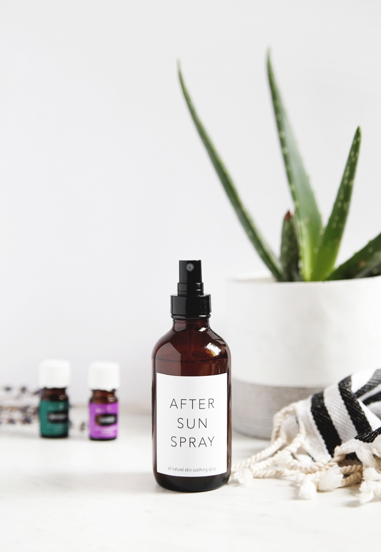 bottle of after sun spray with essential oil bottles and plant