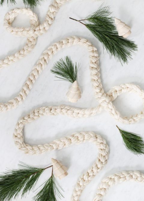 hand crochet garland on marble background with pine and wooden trees