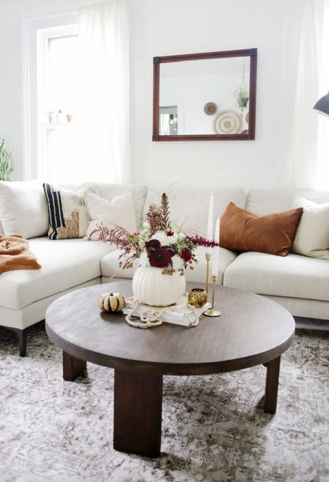 pumpkin vase with florals on coffee table in front of cream couch