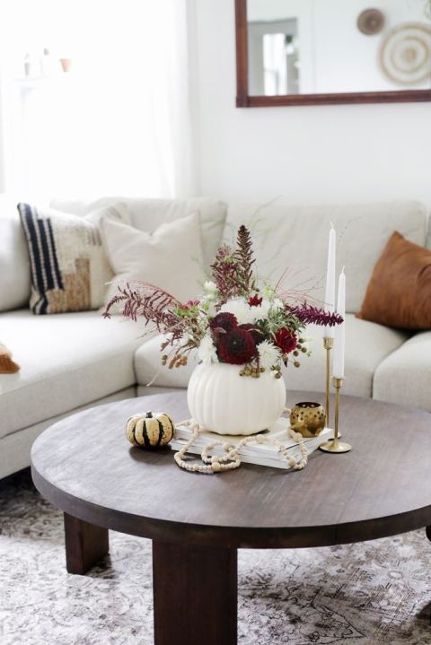 pumpkin vase with florals on coffee table in front of cream couch