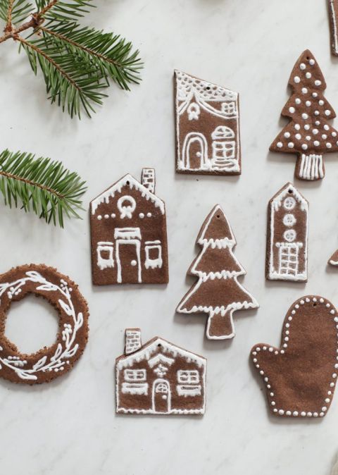 gingerbread ornaments with white paint deigns next to pine