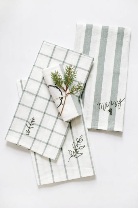 pile of green and white dish towels laid out on white surface