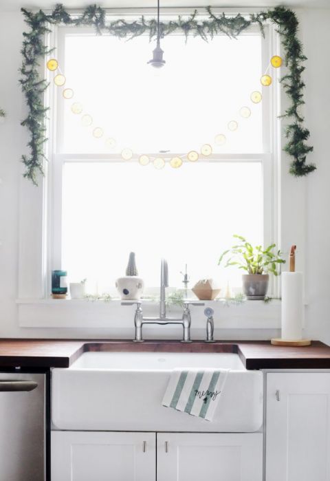 kitchen sink with dish towel hanging from it and window behind sink
