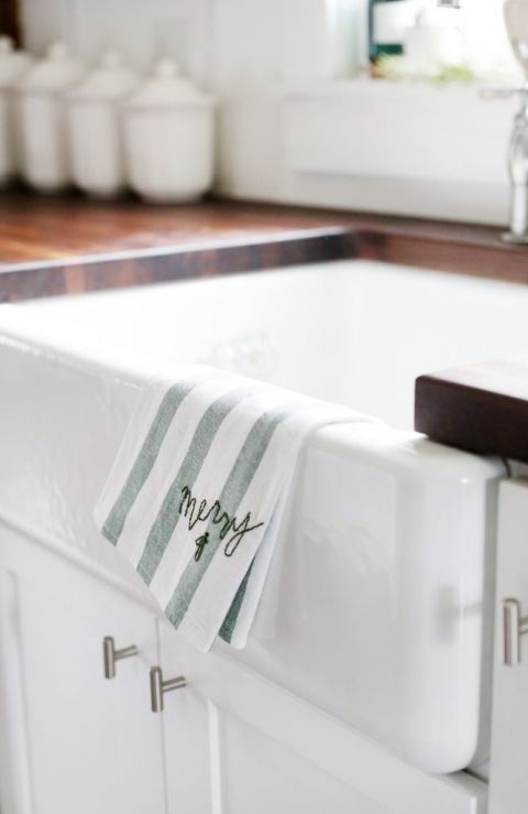 from of white sink with dish towel hanging on it