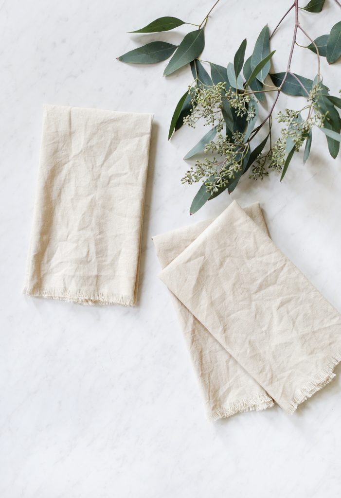 dyed linen napkins laid out on marble counter with eucalyptus
